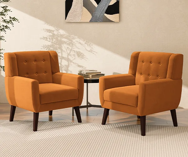 A cozy reading nook featuring two mid-century modern accent chairs in rich burnt orange velvet, designed by Dreamsidea.
