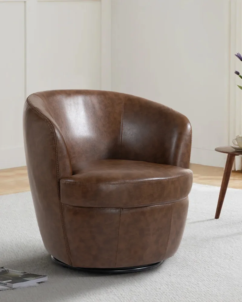 Dreamsidea's modern swivel barrel chair upholstered in a brown faux leather, styled in a serene, minimalist living space.