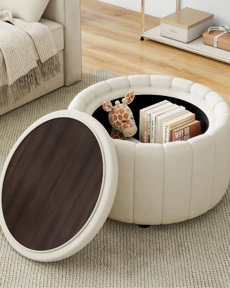 Dreamsidea's round storage ottoman in cream velvet with its wood tray top lid open, revealing a stuffed giraffe and books inside.
